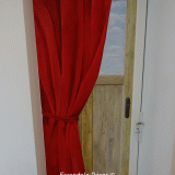Imitation porte en bois flotté et rideau rouge, vue sur jardin
